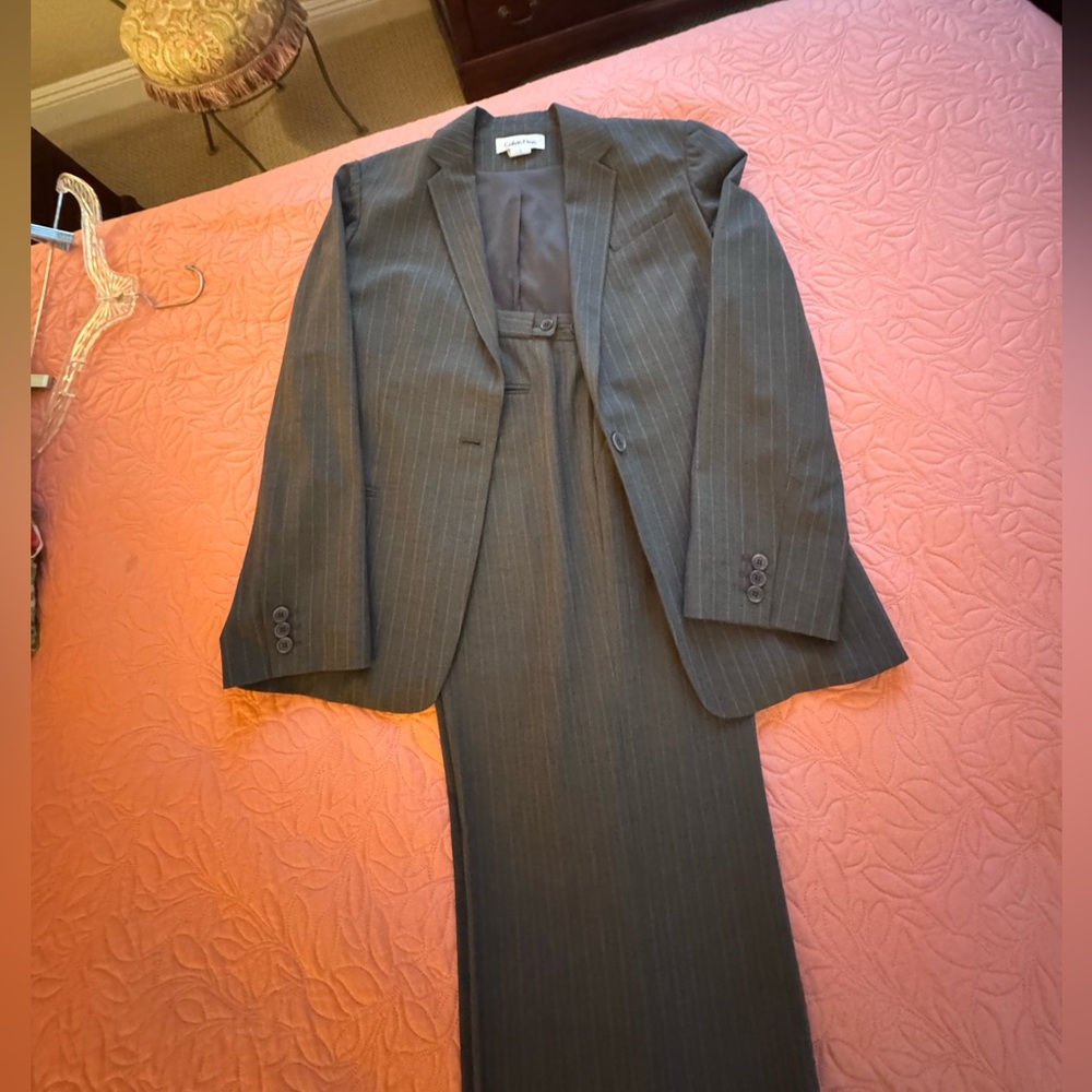 This is a Calvin Klein fully lined pinstripe suit with plates and wide leg.